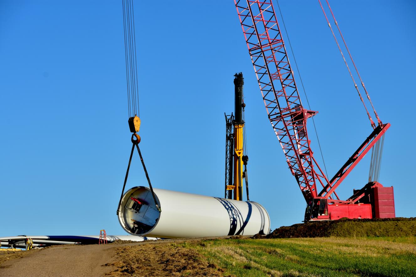 Crane lifting up turbine component during construction